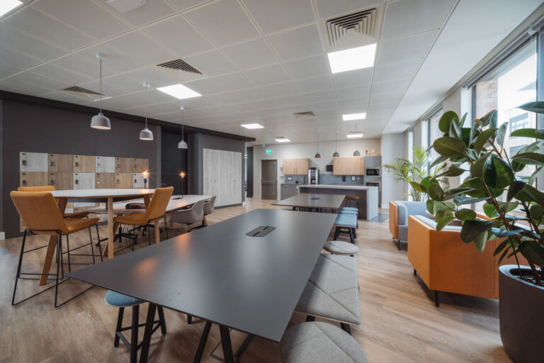 Shot of a long black meeting table and other office furniture in meeting room.