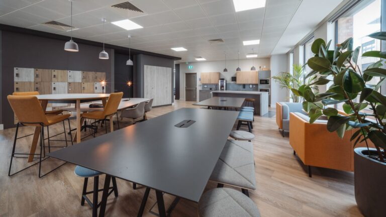 Shot of a long black meeting table and other office furniture in meeting room.