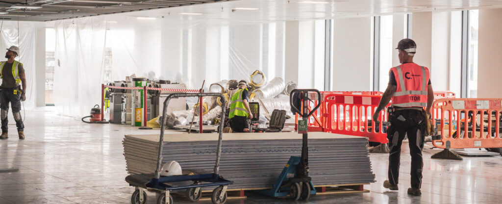 Men on a site with hi-vis vests and hard hats