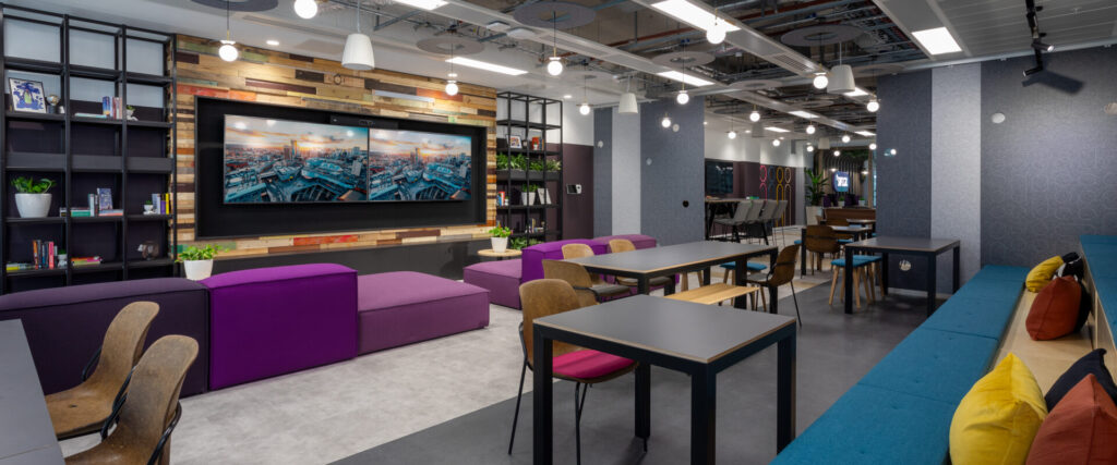 Breakout area with big screens and colorful furnishings